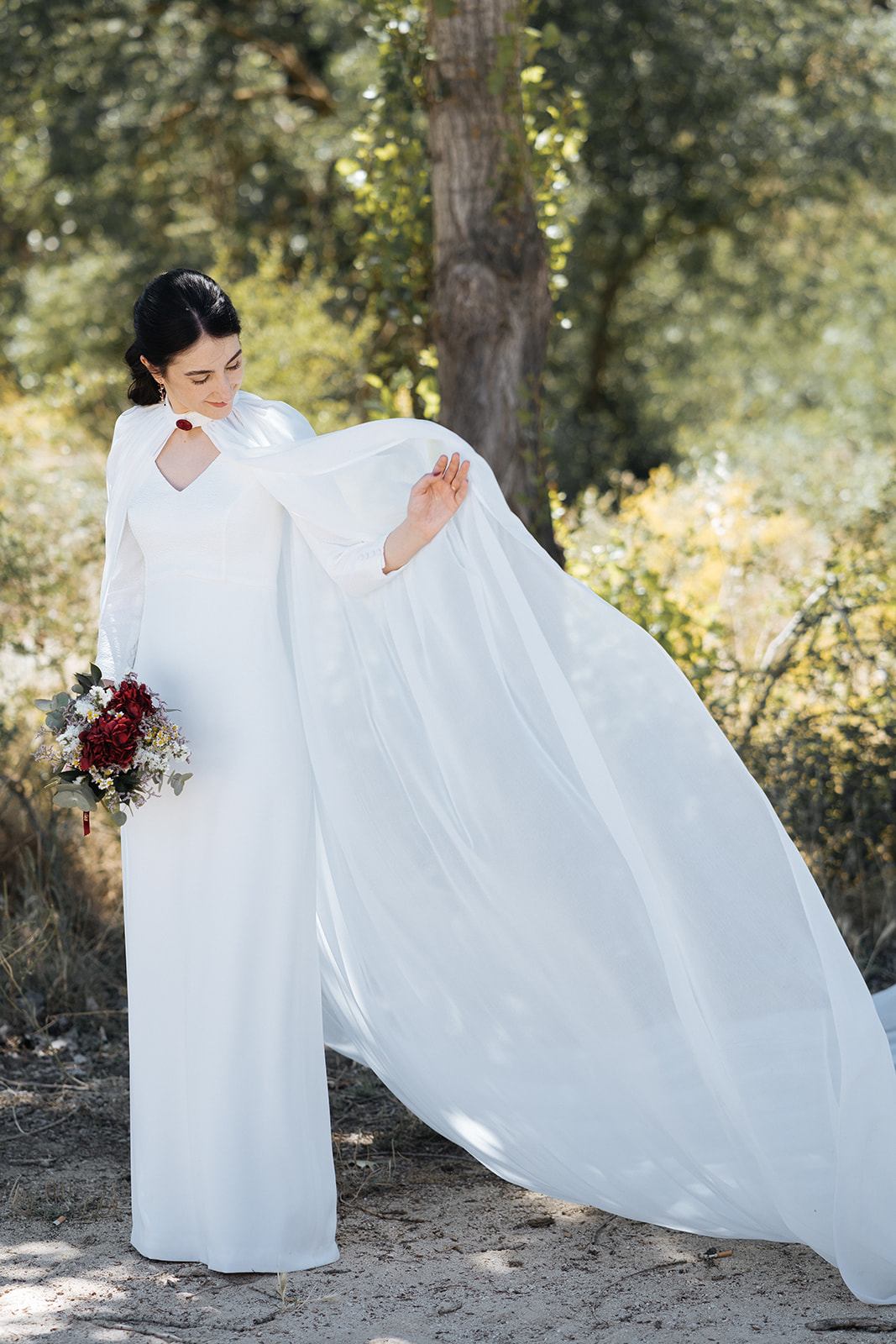 Novia con capa al viento el día de su boda